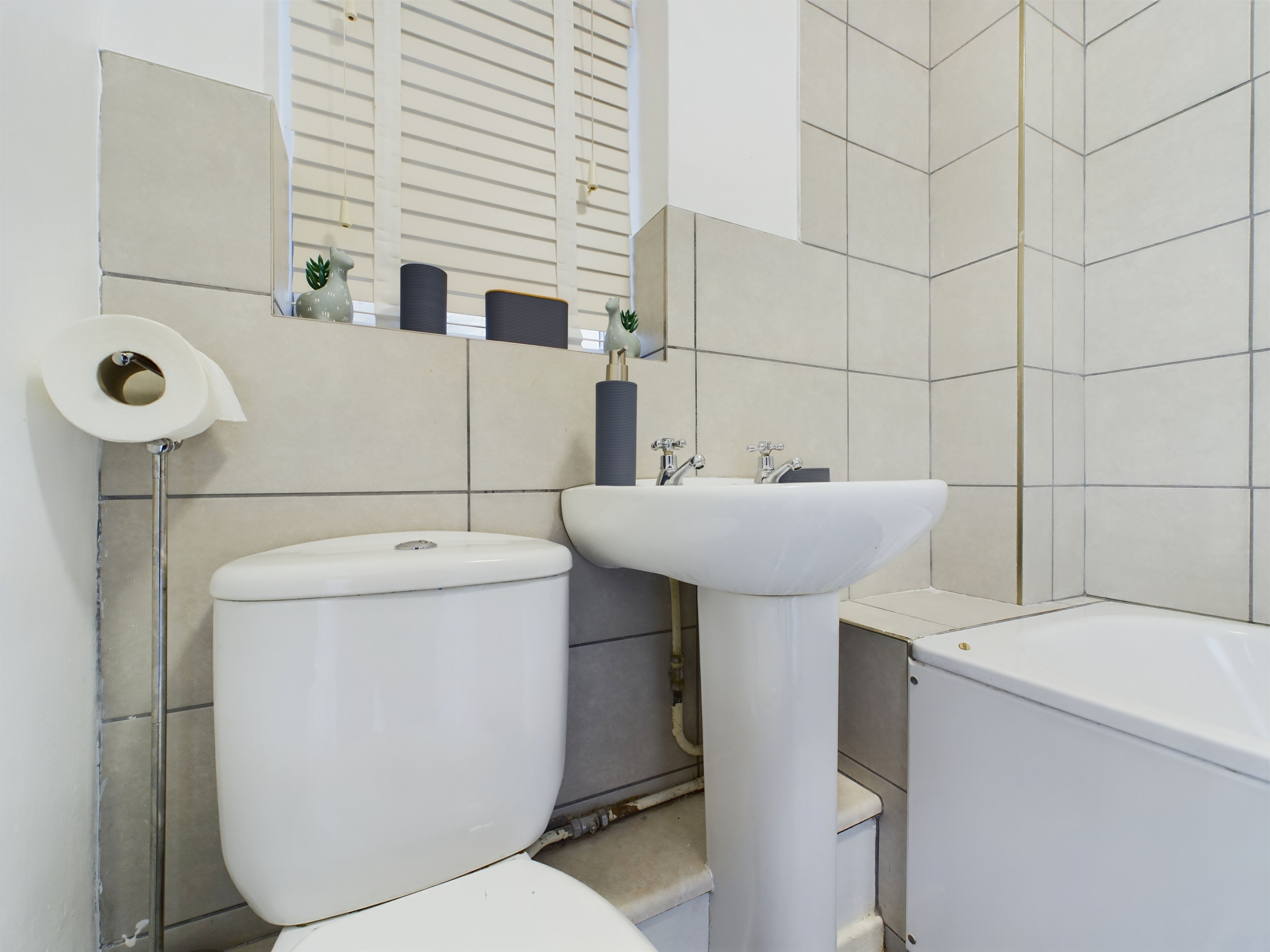 A bathroom with a toilet, sink, and bathtub.