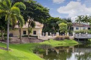 A residential area with a house, a pond, and a bridge.