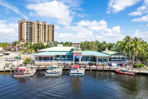 A waterfront hotel with a dock, boats, and a large building in the background.