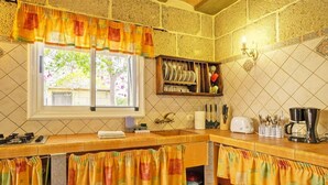A kitchen with a window, a sink, a stove, and a shelf with dishes. - Romantic Getaway in Malpais de Candelaria (Malpais de Candelaria)
