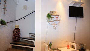 A staircase with a decorative vase and a wall-mounted shelf with plants and a picture frame. - Ferienwohnung am Prüßsee in Güster (Güster)