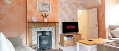 A living room with a fireplace, a television, and a sofa.