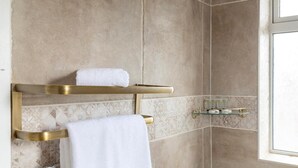 A bathroom with a shower, a towel rack, and a glass shelf. - Charming Frome Retreat With 4 Bedrooms (Frome)