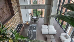 A high-rise interior with a dining area, seating, and large windows offering city views. - Modern apt High Ceilings, BBQ - Morph 401 (Medellín)