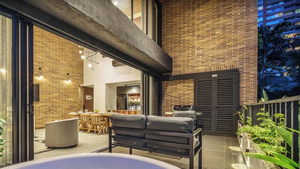 A modern outdoor living area with a hot tub, seating, and a kitchen visible through glass doors. - Modern apt High Ceilings, BBQ - Morph 401 (Medellín)