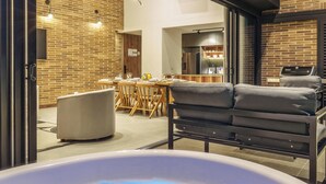 A modern living area with a hot tub, dining table, and comfortable seating. - Modern apt High Ceilings, BBQ - Morph 401 (Medellín)