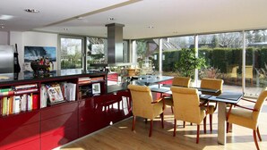 Una cocina moderna con comedor, ventanas amplias y vistas al exterior.