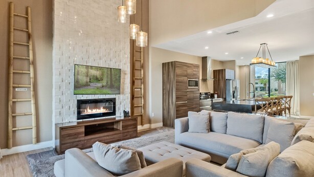 A modern living room with a fireplace, a large flat-screen TV, and a cozy seating area. - Last Minute Disney Getaway! Luxury Villa with Private Pool. Book Now! #66003 (Orlando)