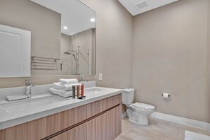 A modern bathroom with a large mirror, a sink, and a toilet. - Last Minute Disney Getaway! Townhouse with Private Pool. Book Now! #66049 (Orlando)