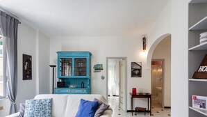 A living room with a white sofa, a blue cabinet, and a bookshelf.
