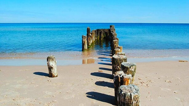 A beach with a wooden structure extending into the water. - Large, 2-story holiday home, sauna, jacuzzi (Mielenko)