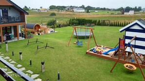 A residential area with a house, a swing set, a trampoline, and a small play area with toys. - Large, 2-story holiday home, sauna, jacuzzi (Mielenko)