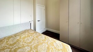 Un dormitorio con cama, armario y puerta.