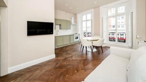 Un apartamento moderno con comedor, cocina y un amplio ventanal con vistas.