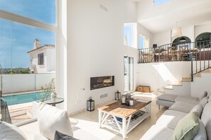 A spacious living area with a pool, a staircase, and a balcony.