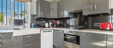A modern kitchen with stainless steel appliances, a dishwasher, and a red toaster.