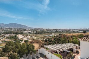 Zona residencial com vista para o horizonte urbano, incluindo edifícios e uma montanha ao longe.