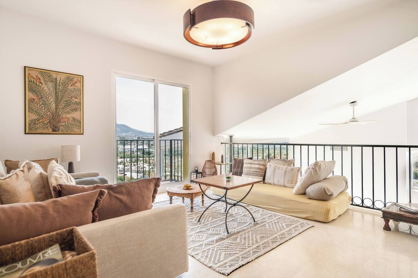 Een ruime woonkamer met een balkon, een eethoek en een groot raam met uitzicht op de stad.