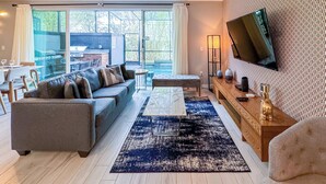 Un salon moderne avec un canapé, une table basse et un téléviseur.