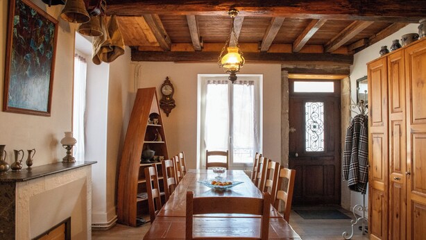 A dining room with a wooden table and chairs, a chandelier, and a fireplace. - Vacation home in the Ouche Valley Situated between Dijon and Beaune.  (La Bussière-sur-Ouche)