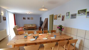 Un coin repas avec une table et des chaises en bois, un canapé et un téléviseur.