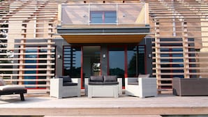 A modern outdoor living area with wicker furniture and a wooden deck.