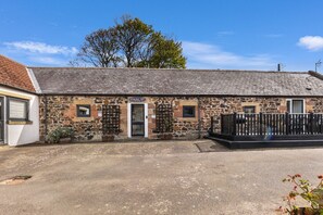 Un bâtiment en pierre sur lequel on peut lire l’inscription suivante : « Bamburgh, première ville. »