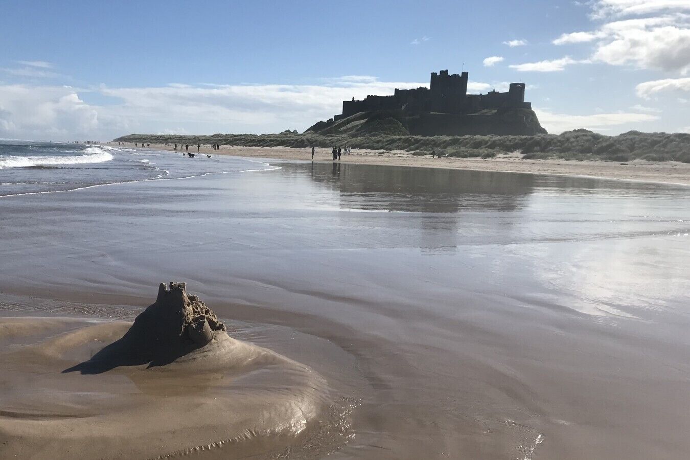 Une plage avec, en arrière-plan, une structure qui ressemble à un château.