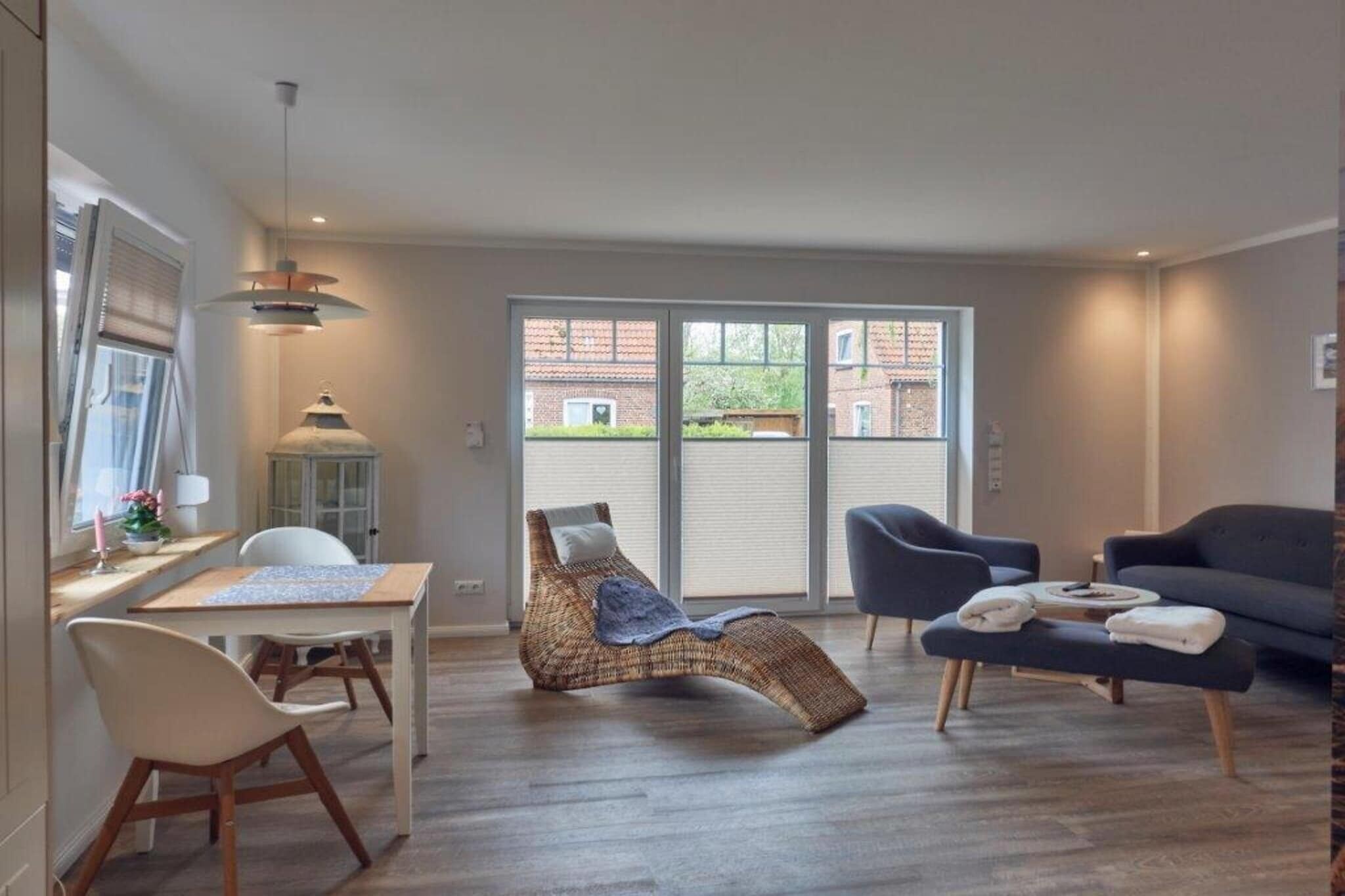 Ein modernes Wohnzimmer mit Essbereich, einem Lounge-Sessel und einer Couch.