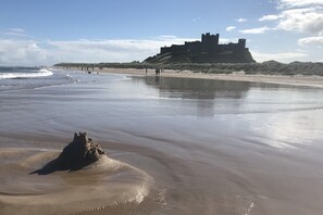 Une plage avec, en arrière-plan, une structure qui ressemble à un château.