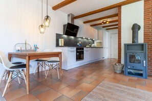 Enjoy cooking in this well-equipped kitchen with an oven, large stove, and wooden dining table.