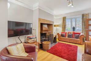 Smart-tv, een open haard, boeken en een stereo