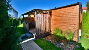 A wooden cabin with a deck and a covered patio area. - Year-round, modern holiday home with a terrace (Ustronie Morskie)