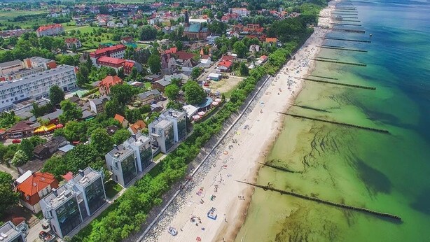 An aerial view of a coastal town with a beach, buildings, and a pier. - Comfortable holiday home with a terrace, Ustronie (Ustronie Morskie)