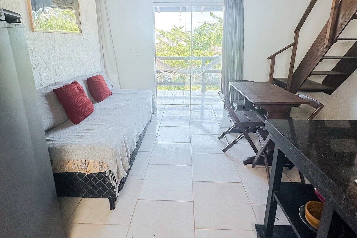 A bedroom with a bed, a desk, and a staircase.