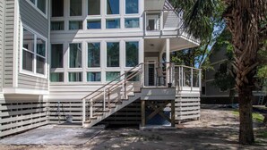 Een meerlaags huis met een opvallende trap die naar een balkon leidt.