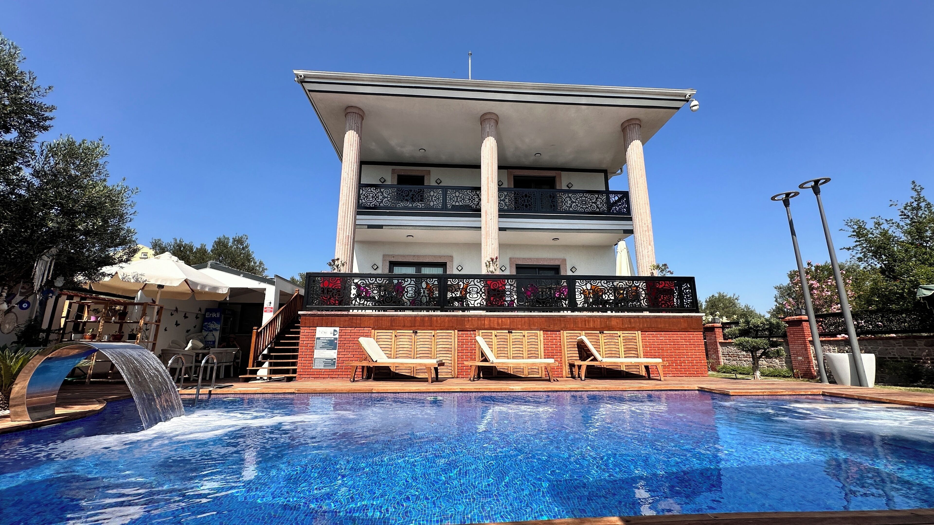 Un bâtiment à deux étages avec une piscine devant.