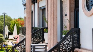 Un edificio con varios balcones, una escalera con barandillas ornamentales y un cartel que dice 'Jeje'.