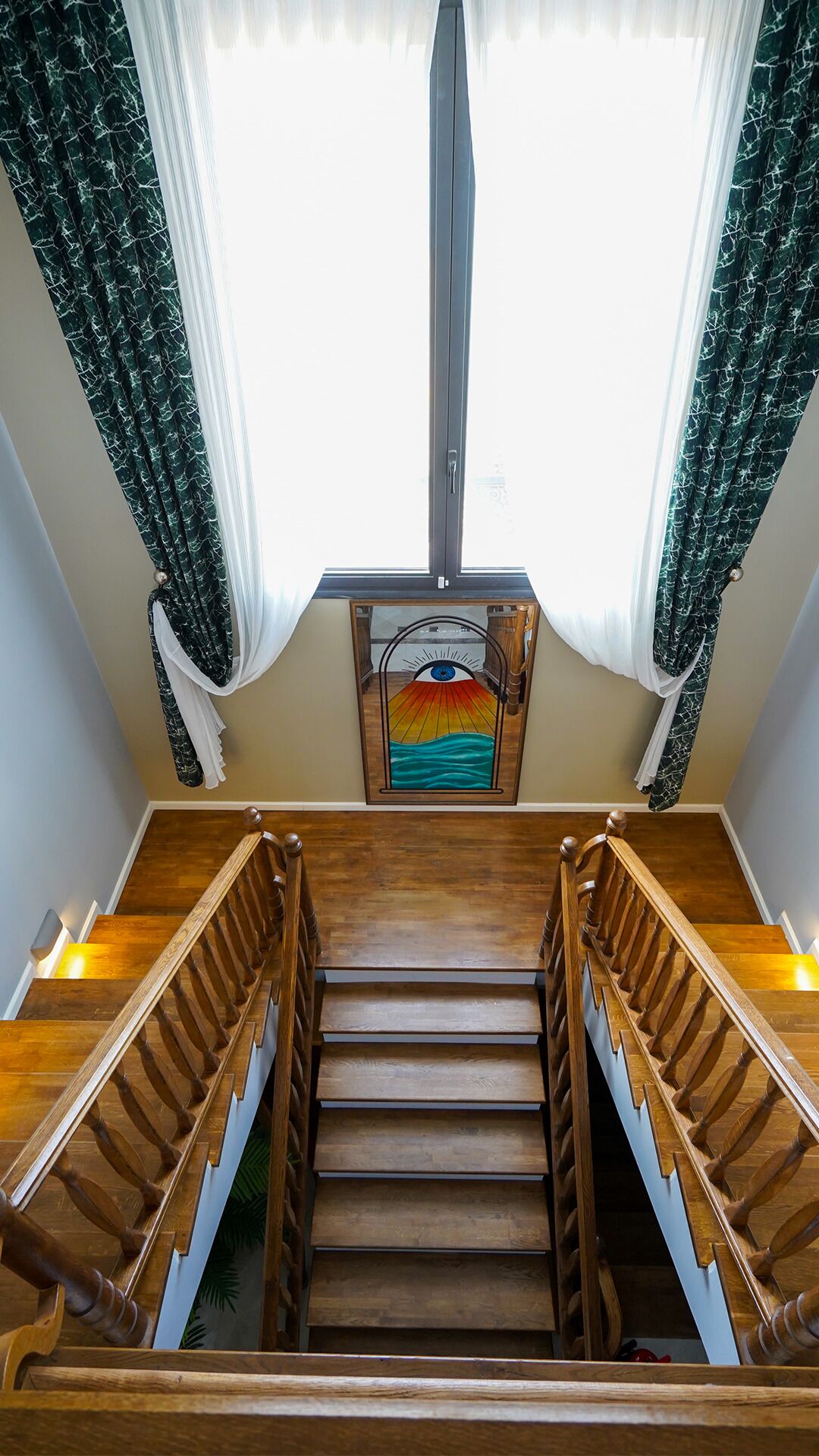 A wooden staircase with a glass panel featuring a colorful artwork.