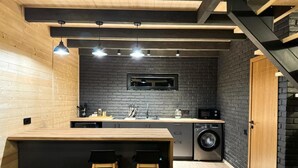 Una cucina compatta con isola centrale, lavatrice e forno a microonde.