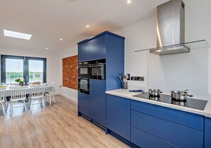 Enjoy cooking in this well-equipped kitchen with an oven, double sink, and stainless steel range hood.