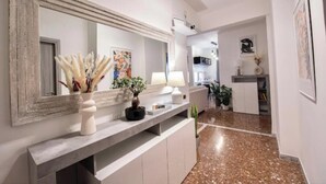 A modern kitchen with a large mirror, a white countertop, and a potted plant. - Spacious and Modern Apartment in the Heart of Rome
 (Roma)