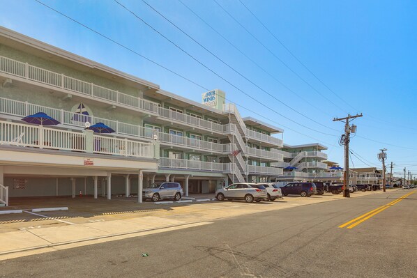 A multi-story hotel with balconies, a 'No Parking' sign, and a 'Four Winds' sign.