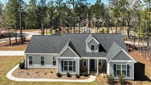 A two-story house with a grey roof and white siding, surrounded by a well-maintained lawn and trees. - Savannah Lakes Village Home: Golf & Hike! (McCormick)