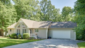 Een gelijkvloers huis met een veranda, een garage en een verzorgd gazon.