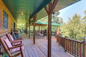 A wooden deck with lounge chairs, a barbecue grill, and a covered area with tables and chairs.