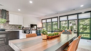 A modern kitchen with a large island, white cabinetry, and a view through large windows. - Game Room, Fire Pit Free Pickleball & Tennis (Helen)