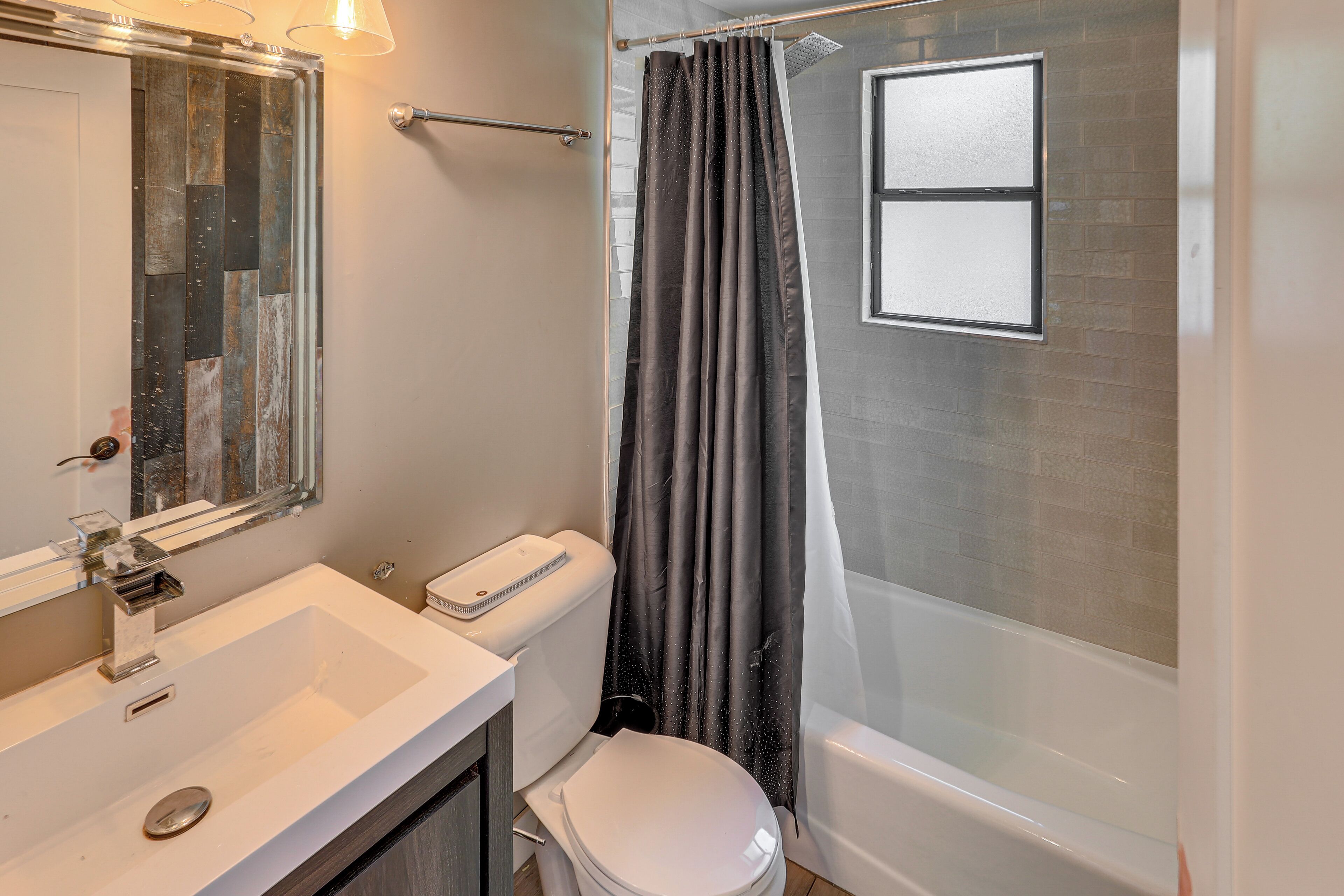Une salle de bain avec un lavabo, des toilettes et une baignoire, le tout de couleur blanche.