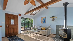 A cozy living room with a sofa, coffee table, and a fireplace. - Waterfront Bayview Bliss Bungalow (Brussels)