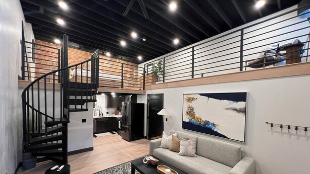 A modern loft-style living space with a staircase, kitchen, and dining area. - DTSF Historic Phillips Loft in the heart of Downtown Sioux Falls (Sioux Falls)